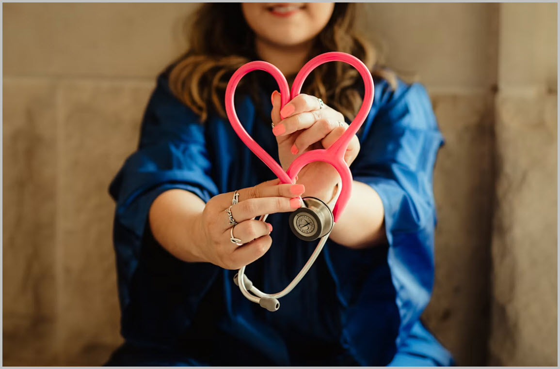 Healthcare professional holding a heart-shaped stethoscope